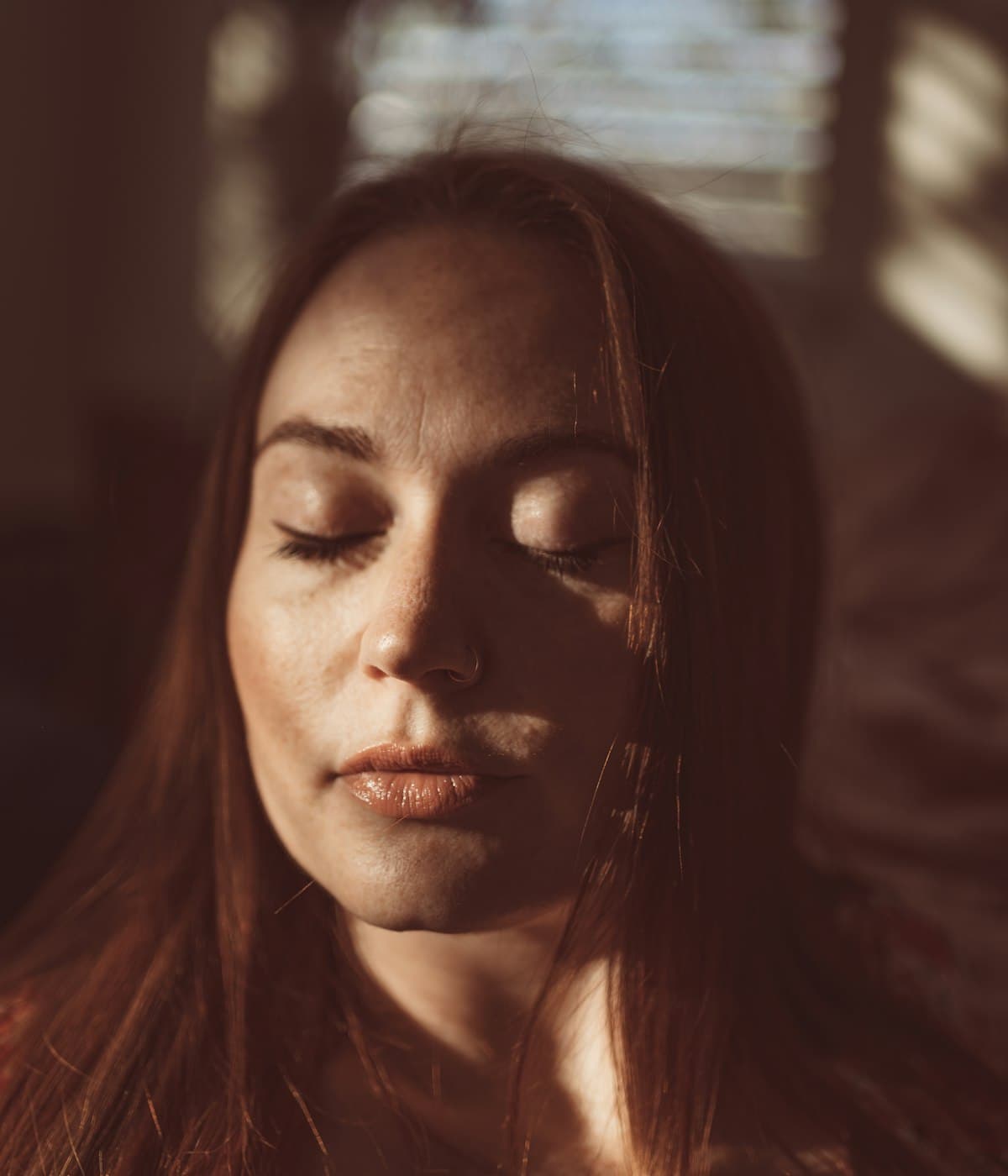 A woman sitting quietly, deep in thought
