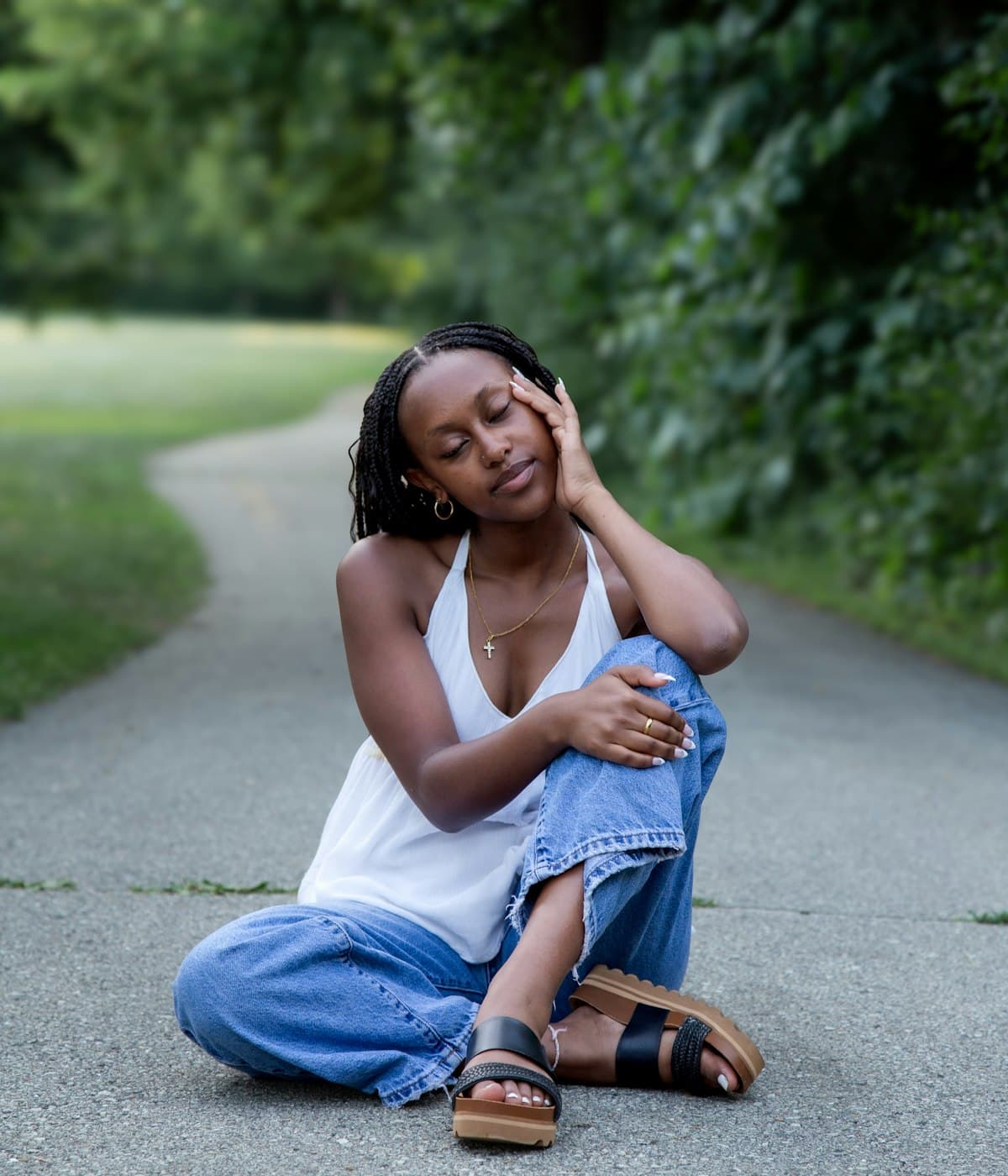 A woman sitting at ease outdoors in warm light